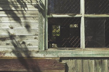 Eski ve yıkık dökük bir binanın penceresi, eski bir boya ve ahşap duvarla. Metin için boş kopyalama alanı.
