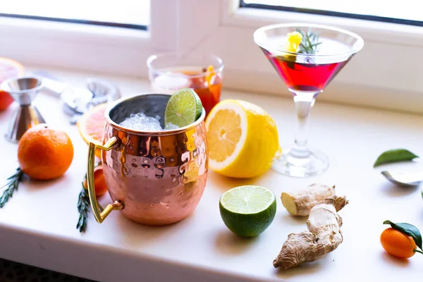 Ev yapımı kokteyller portakallı limonlu, zencefilli, zencefilli ve beyaz arka planda martini Moskova katırı kokteylleri. Sosyal medya ağları için arkaplan İçme tarifi paylaşımları.