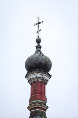 Kilise haçı olan eski tuğla kilise kulesi. Bulutlu ve soğuk kış