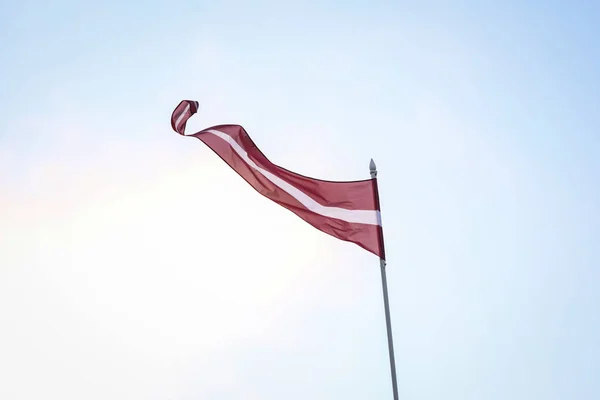 Bandera de Letonia ondeando con viento fuerte . — Foto de Stock