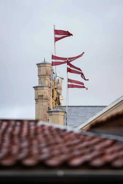 4 σημαίες της Λετονίας που κυματίζουν σε 4 κοντάρια σημαίας με άνεμο. Καθαρό μπλε — Φωτογραφία Αρχείου