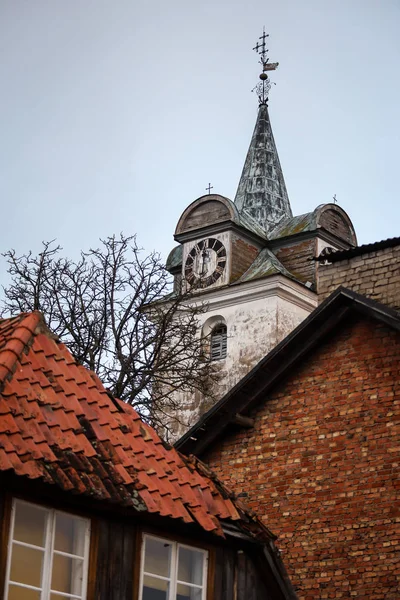 Old white church tower near old city houses on Christmas day.