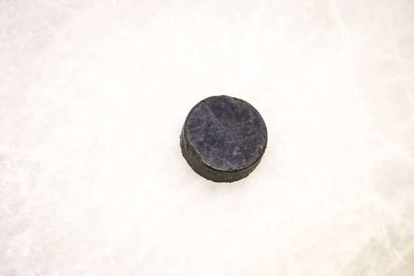 Disco de borracha de hocikey de gelo preto localizado na pista de gelo arena. Gelo e — Fotografia de Stock