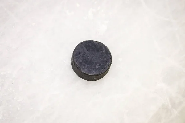 Black ice hocikey rubber puck located on arena ice rink. Ice and — 스톡 사진