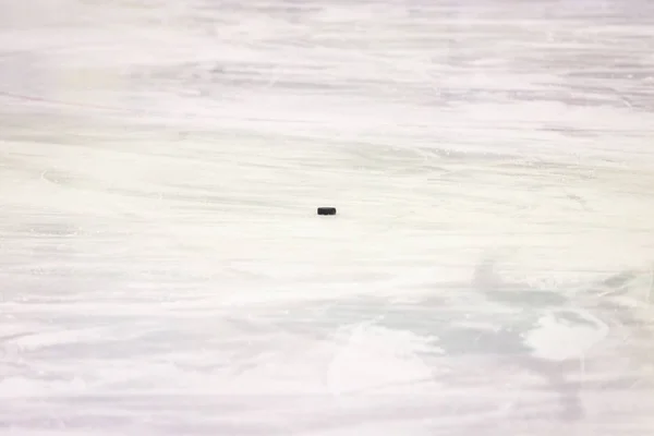 Black ice hocikey rubber puck located on arena ice rink. Ice and — 스톡 사진