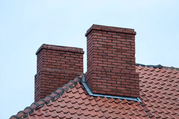 Hausdach-Ansicht von zwei Schornsteinen bei bewölktem Himmel. — Stockfoto