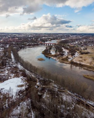 Venta nehri ile Kuldiga kırsalının gerçek insansız hava aracı görüntüsü. Fotoğraf, ılık kış gününde karlı bir günde çekildi..