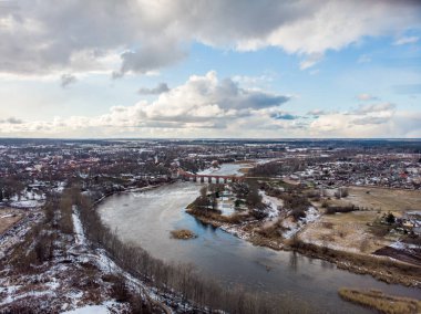 Venta nehri ile Kuldiga kırsalının gerçek insansız hava aracı görüntüsü. Fotoğraf, ılık kış gününde karlı bir günde çekildi..