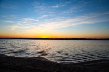 Gecenin geç saatlerinde mavi nehir kenarında gün batımı. Fotoğraf Avrupa, Letonya 'da çekildi.