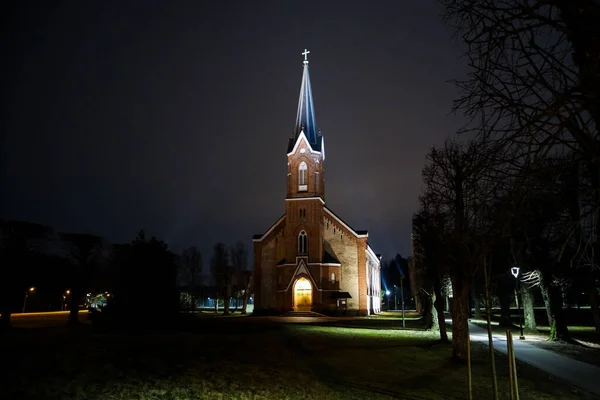 Akşamın ilerleyen saatlerinde aydınlatılmış ışıklarla güzel bir yerel kilise manzarası. Fotoğraf Avrupa, Letonya 'da çekildi.