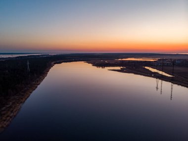 Nehir Lielupe Coutnryside manzarası gün batımında güzel bir çam ağacı ormanıyla kıyı şeridine yakın