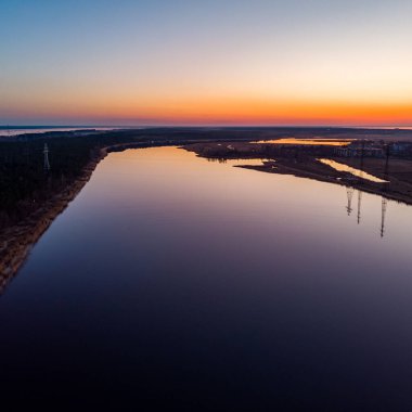 Nehir Lielupe Coutnryside manzarası gün batımında güzel bir çam ağacı ormanıyla kıyı şeridine yakın