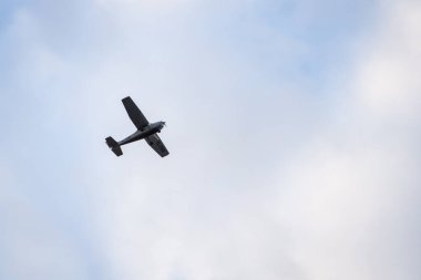 Bulutların üstünde uçan küçük bir uçak. Fotoğraf bulutlu bir günde çekildi, Avrupa, Letonya.