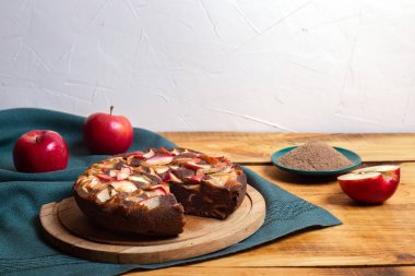 Keten unlu glüten turtası ve yeşil kumaş ve ahşap masa üzerinde elmalar.