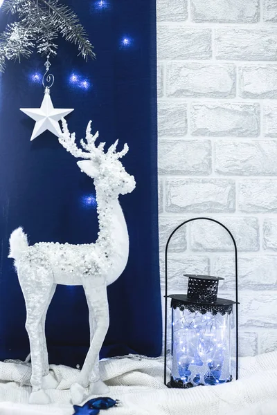 Vánoční dekor bílý jelen s tmavou a skleněnou lucernou a světly na modrém a bílém pozadí v barvě roku 2020 Classic Blue — Stock fotografie