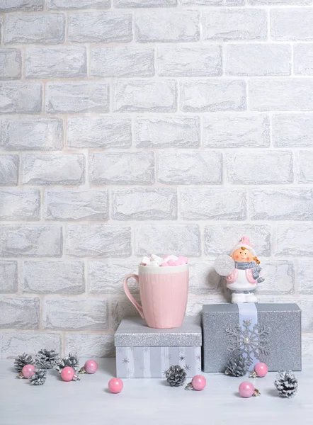 Giocattoli di Natale, coni, palle rosa e regali d'argento su uno sfondo di mattoni grigio chiaro — Foto Stock