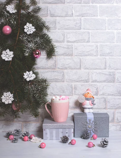 Vánoční strom borovice Větve s ručně dělané sněhové vločky, stříbrné dárky, růžový šálek, kornouty a koule a vánoční hračka na lehkém vertikálním pozadí. Nový rok — Stock fotografie