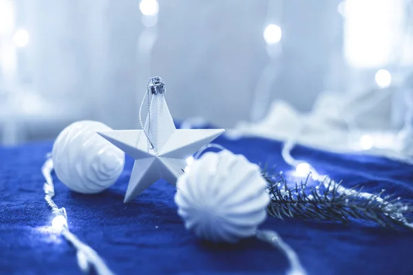 Weihnachtsdekor weißer Stern, Kugeln und Lichter auf blauem Tuch in der Farbe des Jahres 2020 klassisch blau — Stockfoto