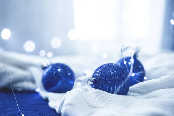 Weihnachtsdekor blaue Kugeln und Lichter auf weißem Tuch in der Farbe des Jahres 2020 klassisch blau — Stockfoto