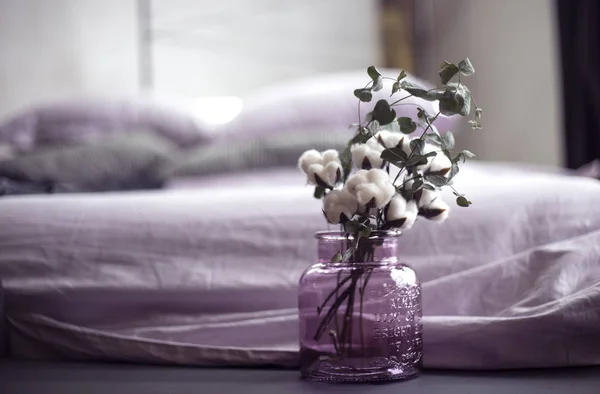 Красива баня з бавовни в бузковій скляній вазі в інтер'єрі спальні — стокове фото