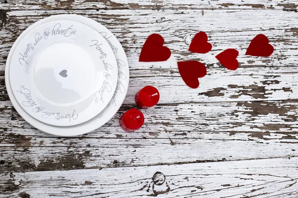 Valentinenes romantiske bord, røde hjerter med hvite plater og røde lys på hvit trebakgrunn. Kopirom, tomt sted for tekst. Sett ovenfra, flatt dekke , – stockfoto
