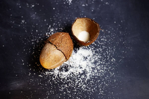 Koyu gri arka planda hindistan cevizi taneleri olan tropikal meyveler. Yatay, kopyalama uzayı. Üst görünüm