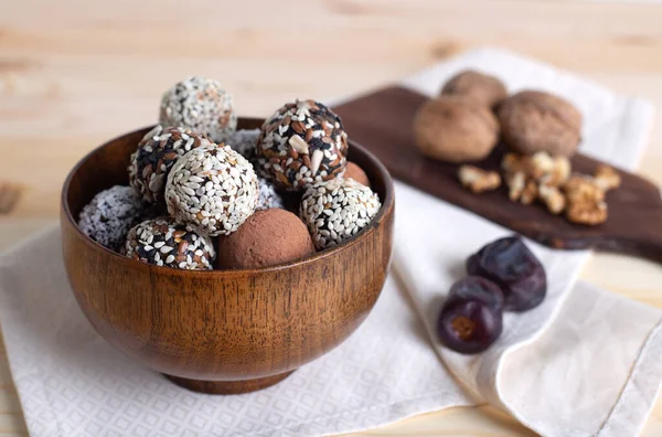 Tahta kasede çiğ protein topları cevizli ve hafif peçeteyle hurma. Enerji topları malzemeler, fırın yok. Seçici odak, yatay, kapat