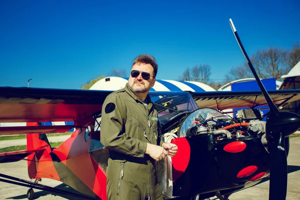 Pilot küçük uçakları tamir ediyor. Havalimanında, çok hafif bir uçağın yanında, uçuş kıyafetli bir adam var. Kitfox 4. Mavi gökyüzüne karşı özel uçağın kendi kendine bakımı