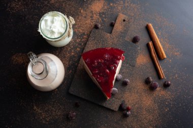 Soya sütü, keçiboynuzu ve meyve reçelinden yapılan diyet tatlı. Cam kavanozda beyaz yoğurt ve siyah akımlı kakao ve siyah arka planda tarçın. Yaz için güzel bir tatlı. Üst görünüm