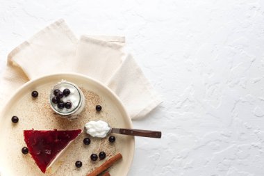 Soya sütü, keçiboynuzu ve vişne ve siyah frenk üzümlü meyve jölesinden yapılan diyet katmanlı tatlı. Beyaz arka planda cam kavanozda beyaz yoğurt. Güzel tatlı. Üst görünüm