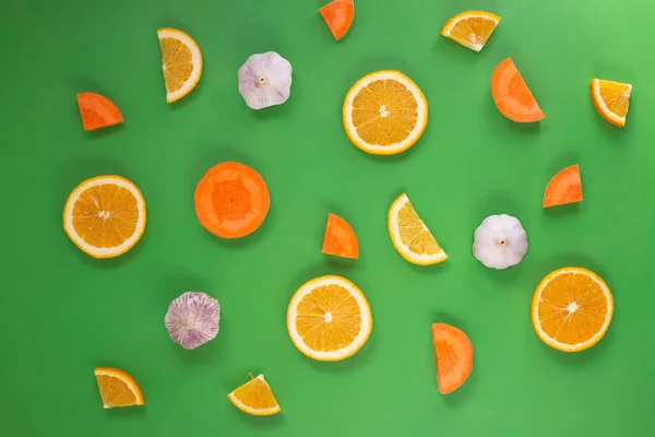 Yeşil arka planda Coronavirus hastalığının korunması için taze sağlıklı besin. Bir parça portakal, havuç ve sarımsak. Üst görünüm yaratıcı kavram