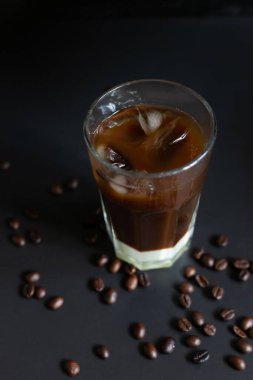 Geleneksel Vietnam buzlu kahvesi, yoğun süt ve koyu grunge arkaplanda kahve çekirdekleri. Bardağa biraz buz koy, yaz sabahı için en iyi içecek. Alçak tuş, dikey