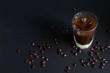 Geleneksel Vietnam buzlu kahvesi, yoğun süt ve koyu grunge arkaplanda kahve çekirdekleri. Bardağa biraz buz koy, yaz sabahı için en iyi içecek. Alçak tuş, yatay, kopyalama alanı
