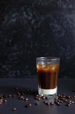 Geleneksel Vietnam buzlu kahvesi, yoğun süt ve koyu grunge arkaplanda kahve çekirdekleri. Bardağa biraz buz koy, yaz sabahı için en iyi içecek. Alçak tuş, dikey, kopyalama alanı