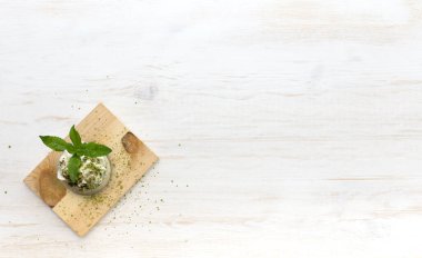 Aquafaba ile sağlıklı bir eşleşmeli tatlı. Tahtadaki cam kavanoz tarafsız arkaplanda fotokopi alanı ile birlikte. Üst Manzara. Vejetaryenler için yeşil kibrit. Kilo kaybı konsepti, glütensiz, şekersiz tatlı