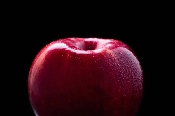 Wet red apple fading into black background — Stock Photo, Image