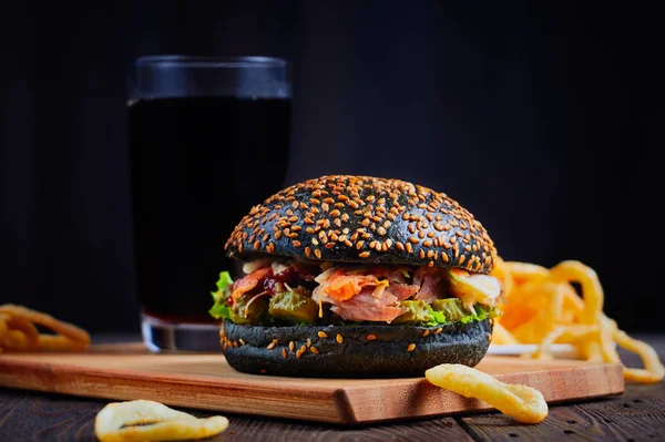 Burger noir sur planche à découper en bois isolé Images De Stock Libres De Droits