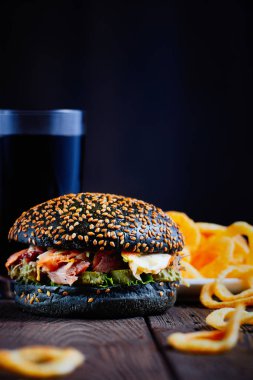 Tahta kesme tahtasındaki siyah burger.