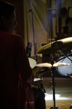 Bir davulcunun silueti enstrümanını çalarken