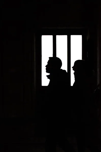 silhouette of man and woman going through a window