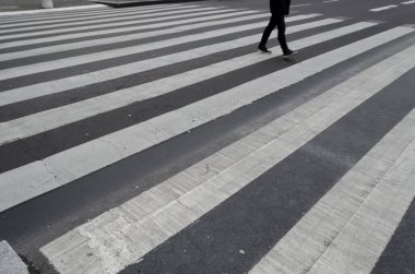 Yaya zebraların arasından karşıya geçen birinin bacakları.