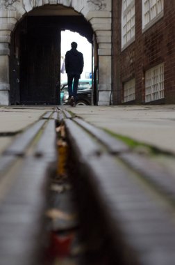 Dışarı çıkmak için kemeri geçen genç bir adamın siluetinin zemin katı.