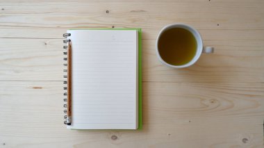 Tahta masada yeşil çay ve defter