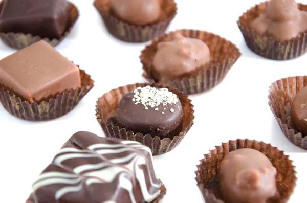 chocolate candies in a candy wrapper on a white background. A set of sweets with different tastes ..