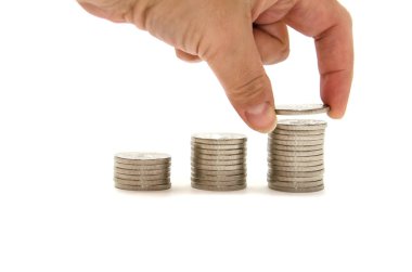 El, beyaz arka planda gümüş paraları istifler. Yakın plan. Büyüme ve para biriktirme kavramı.