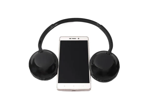 白い背景に黒いヘッドフォンとスマートフォン — ストック写真