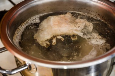 meat broth with pork ribs boils in a pan. Close-up.