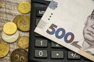 500 hryvnias, coins and part of the calculator. Close-up.