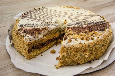 Yoğunlaştırılmış süt ve ahşap bir masada haşhaş tohumlu lezzetli bir pasta. Pasta parçalara ayrıldı..