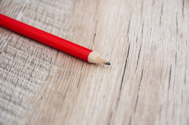 Ahşap arka planda kırmızı kalem. Yakın plan..